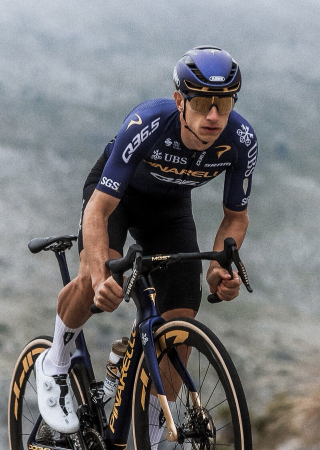Q36.5 Pro Cycling Team rider climbing in full team kit